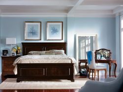 Bedroom photograph with furniture and custom framed art hanging above the bed.